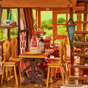 Miniature wooden dining set with table, chairs, and decorative items in a dollhouse setting.
