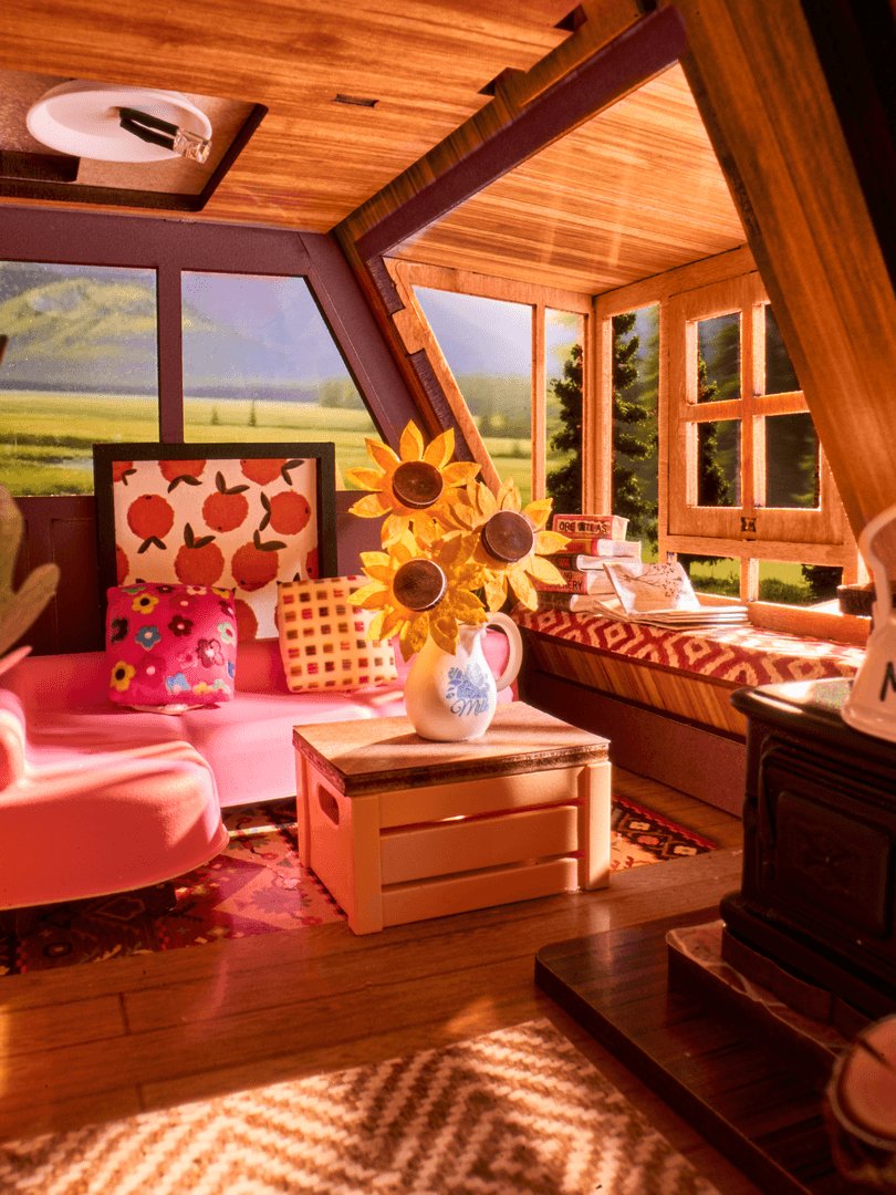 Wooden interior with pink furniture, sunflower arrangement, and scenic window view.