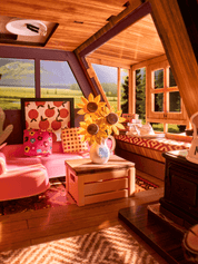 Wooden interior with pink furniture, sunflower arrangement, and scenic window view.