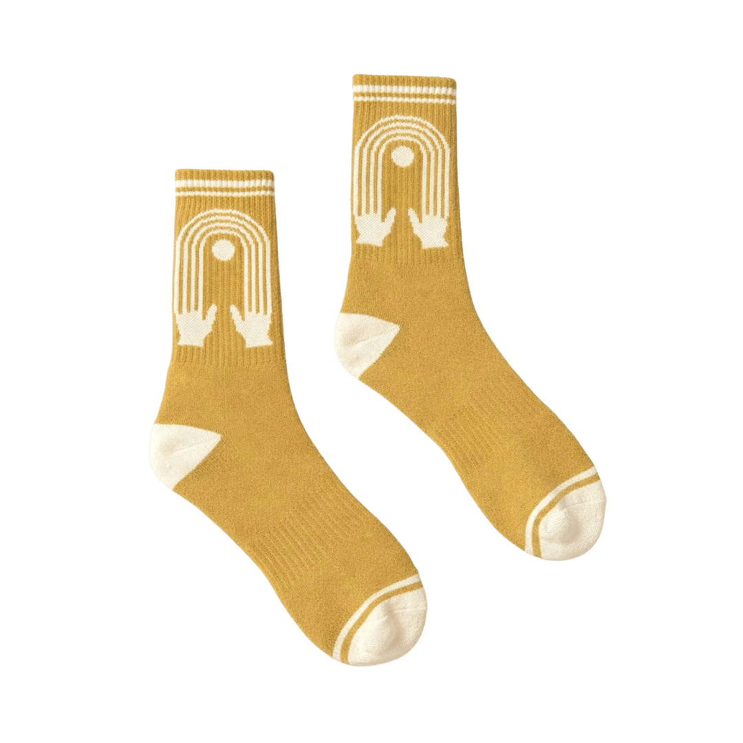 Pair of mustard yellow socks with white geometric patterns.