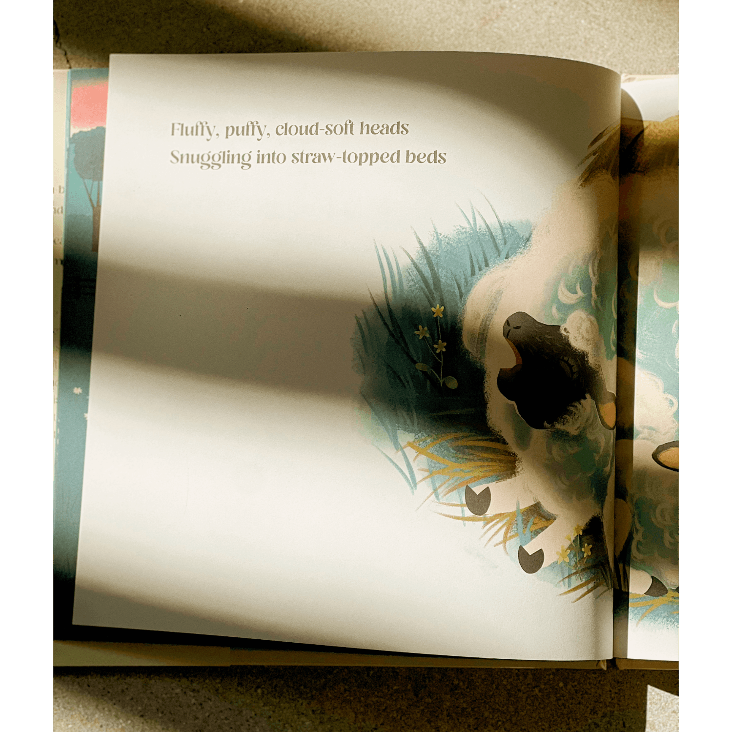 Open book with a page showing an illustration of a sheep and text.