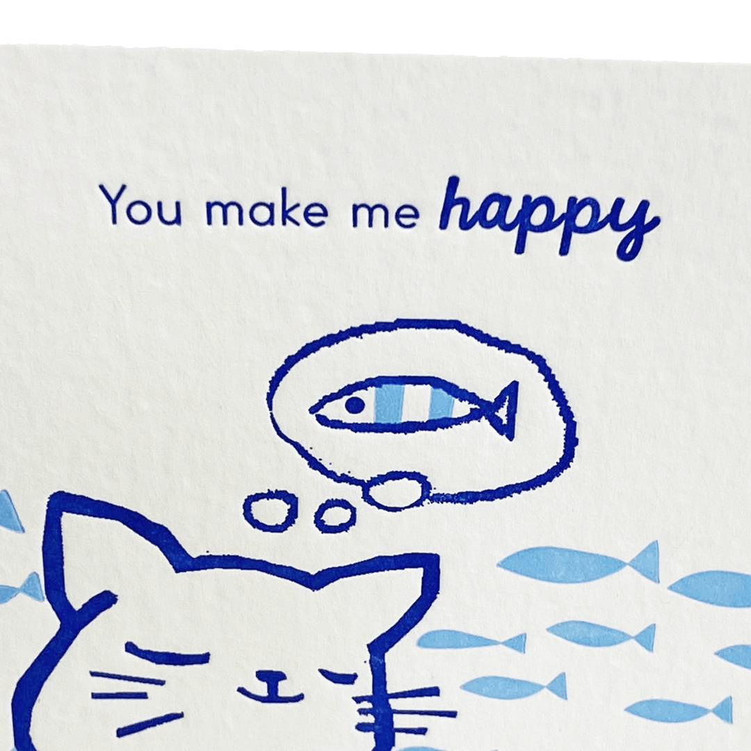 Cartoon cat with thought bubble containing a fish, surrounded by more fish, on a white background with 'You make me happy' text.