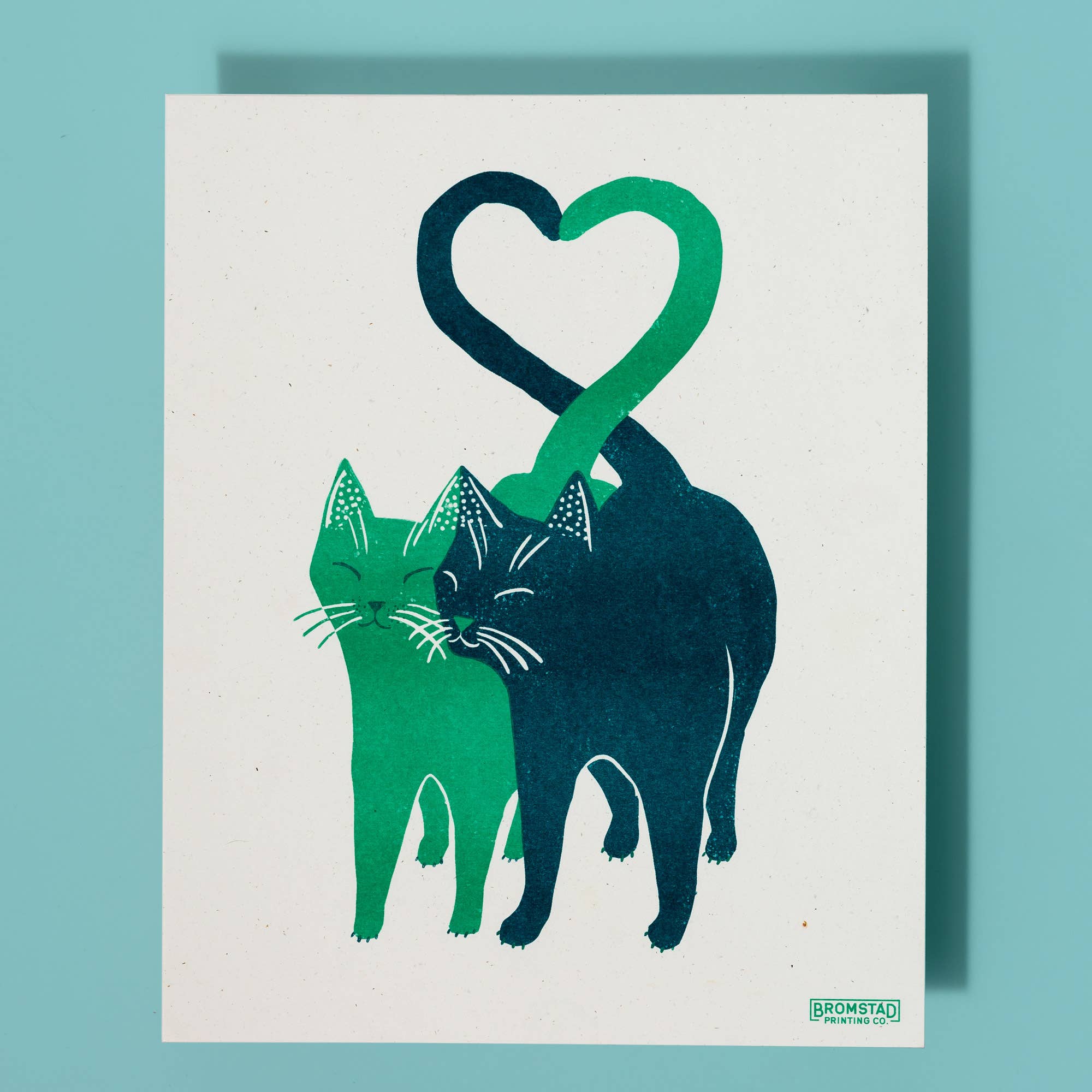 Illustration of two cats forming a heart shape on a white background on a blue surface
