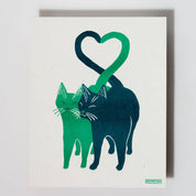Illustration of two cats forming a heart shape on a white background