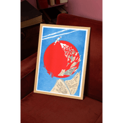 Framed artwork with a red circle and blue background on a red couch.