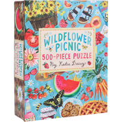 Box of 'Wildflower Picnic' 500-piece puzzle by Katie Daisy with colorful illustrations of picnic details on a blue background.