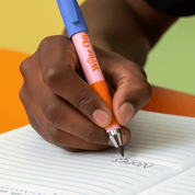 Hand holding a pen over a notebook