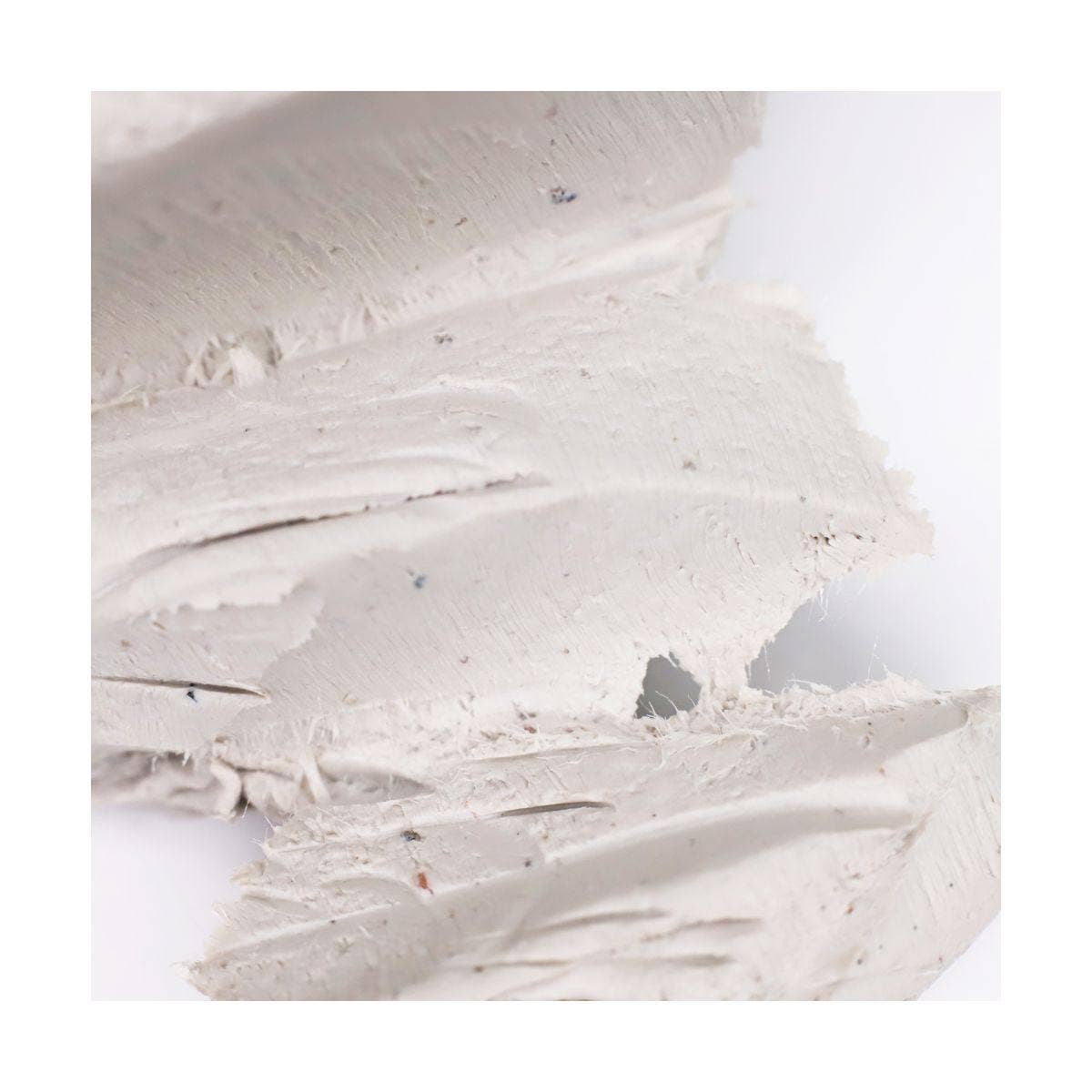 Close-up of clay with visible texture on a white background