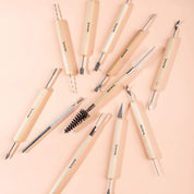 Set of clay tools with wooden handles on a pink background