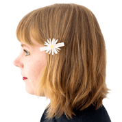Profile of a person with a white flower hair clip