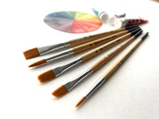 Set of paintbrushes with a color palette on a white background