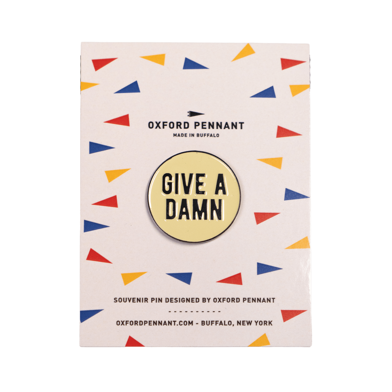 Pin with 'Give a Damn' text on a colorful patterned card by Oxford Pennant