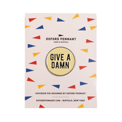 Pin with 'Give a Damn' text on a colorful patterned card by Oxford Pennant