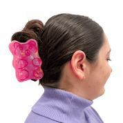 Large pink gummy bear shaped hair clip in a person's hair