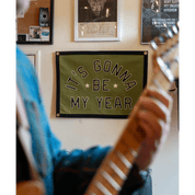 Person playing guitar with a motivational banner on the wall