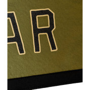 Close-up of a green fabric with black letter 'R' patch