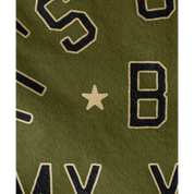 Close-up of a green fabric with black and gold lettering and a star.