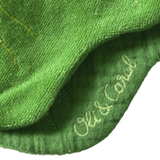 Close-up of green fabric with 'Oli & Carol' branding.