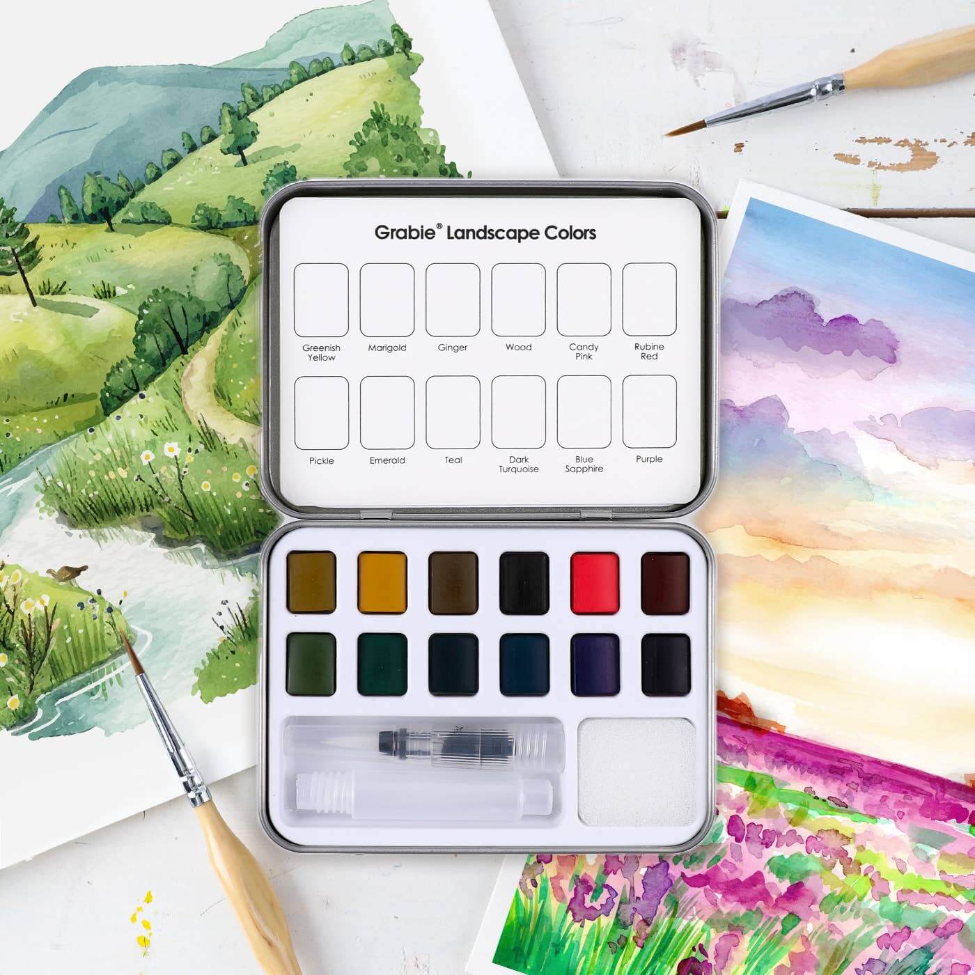 Watercolor paint set with landscape paintings in the background