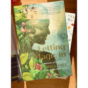 Book titled 'Letting Magic In' by Maia Toll on a wooden surface