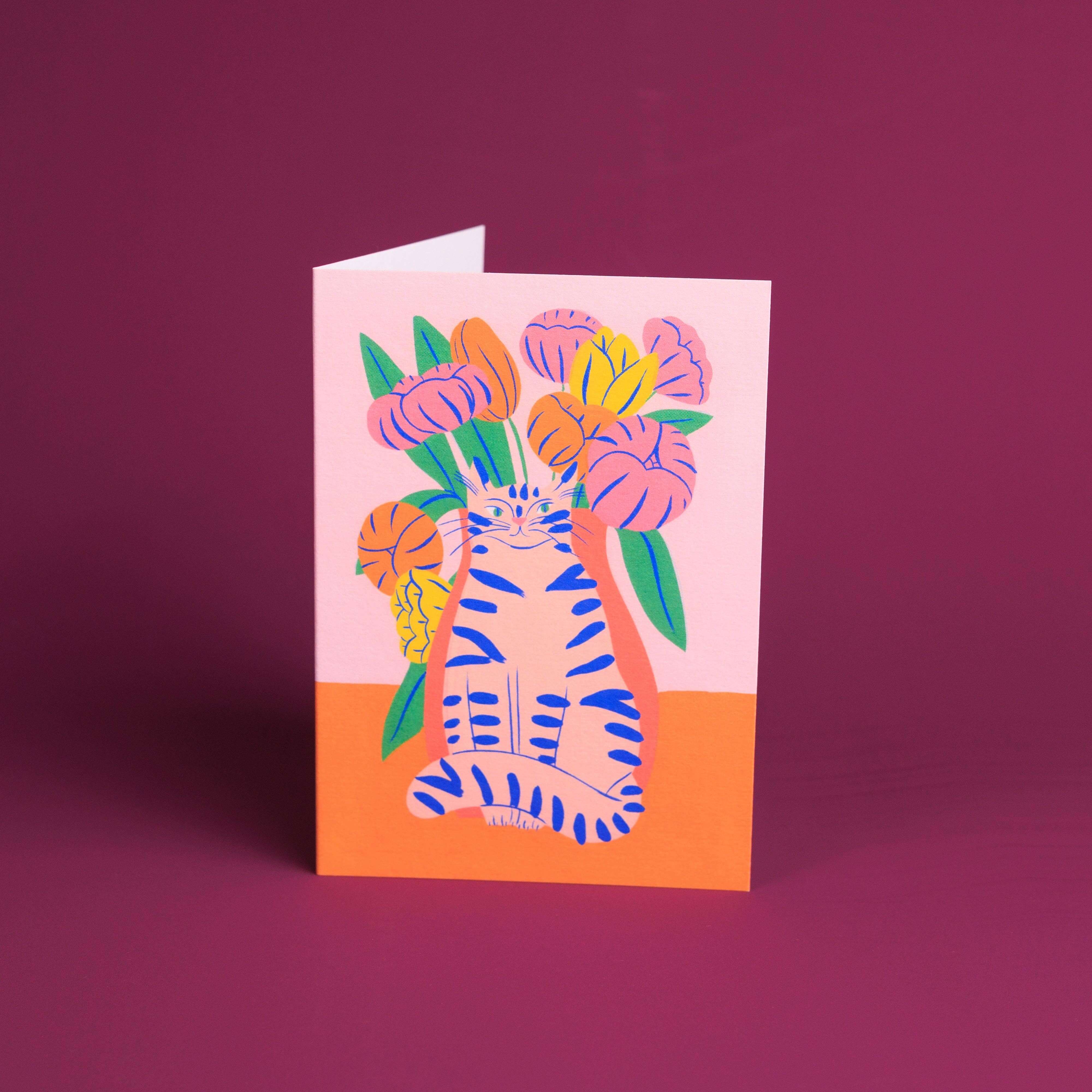 Greeting card with a zebra holding flowers on a pink and orange background