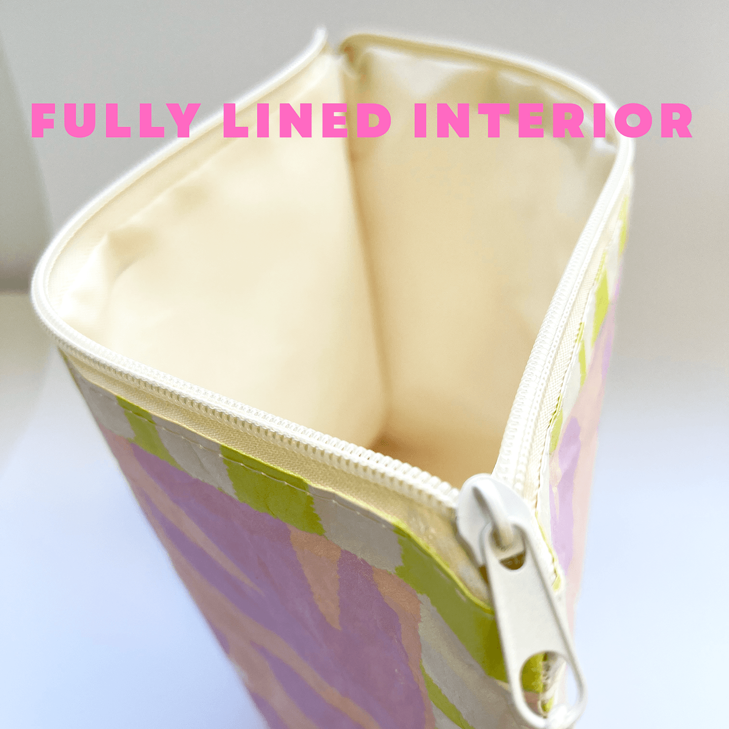 Zipped pouch with colorful pattern on a white background, text 'FULLY LINED INTERIOR' displayed.