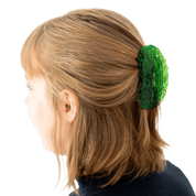 Person with green pickle hair clip in light brown hair