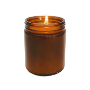 A lit candle in a glass jar.