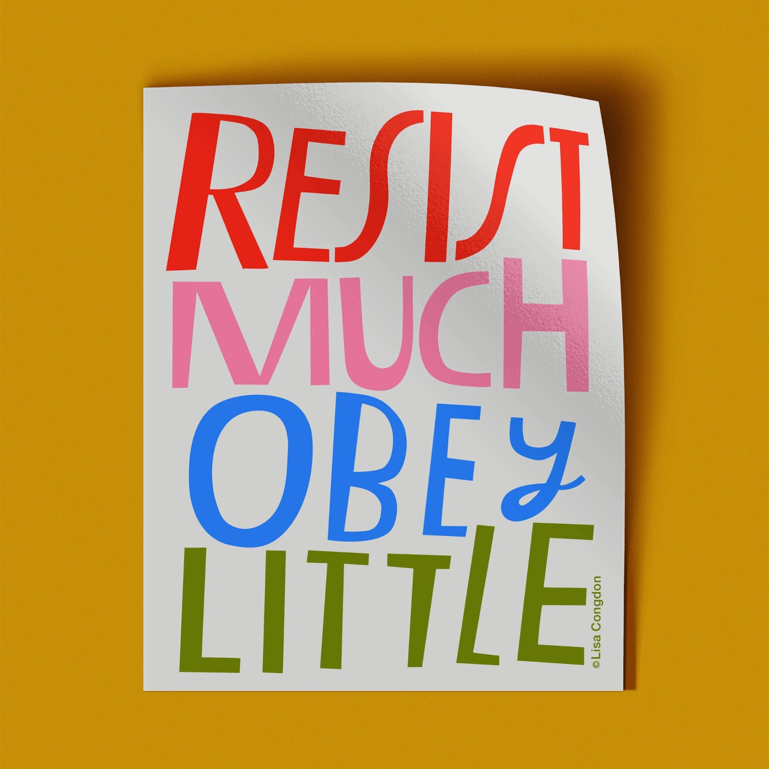 Colorful text sticker with motivational quote on a white background laying on a yellow orange surface.