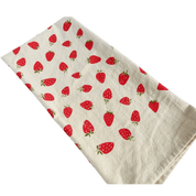 Beige towel with red strawberry pattern.