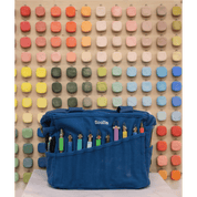 Blue painter's bag with colorful tools against a colorful pegboard background