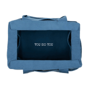 Inside of a blue painter's bag with 'YOU DO YOU' text on the bottom of the bag.