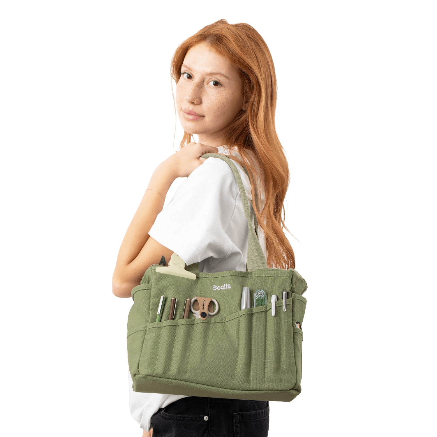 Woman holding a green painters bag with various tools in the pockets. 