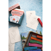 Paintable flower watercolor cards with a box and paint blocks on a textured surface