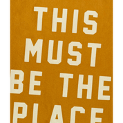 Text 'THIS MUST BE THE PLACE' on a mustard yellow background