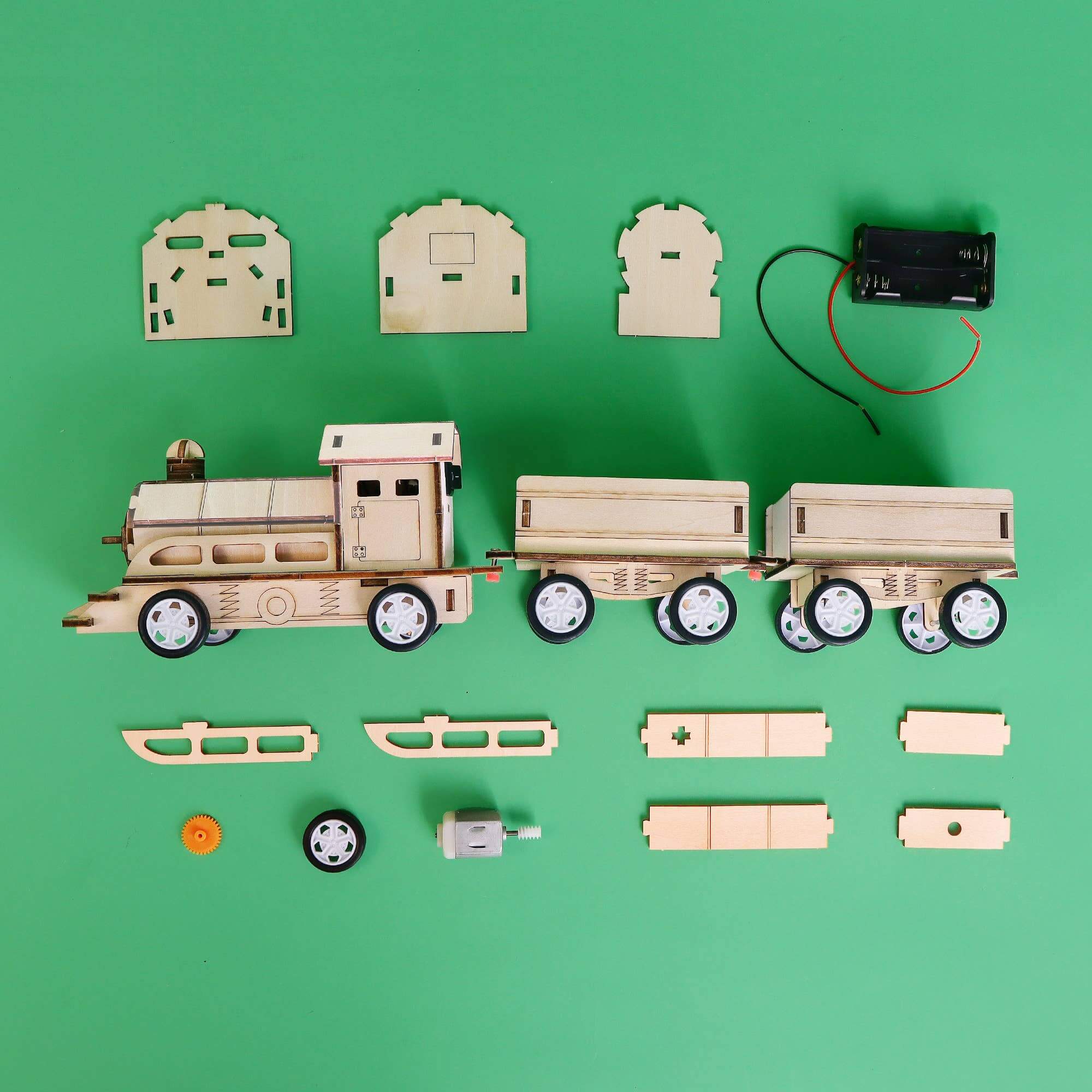 Wooden toy train set with components on a green background