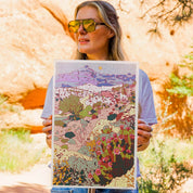 Woman holding a colorful landscape illustration outdoors